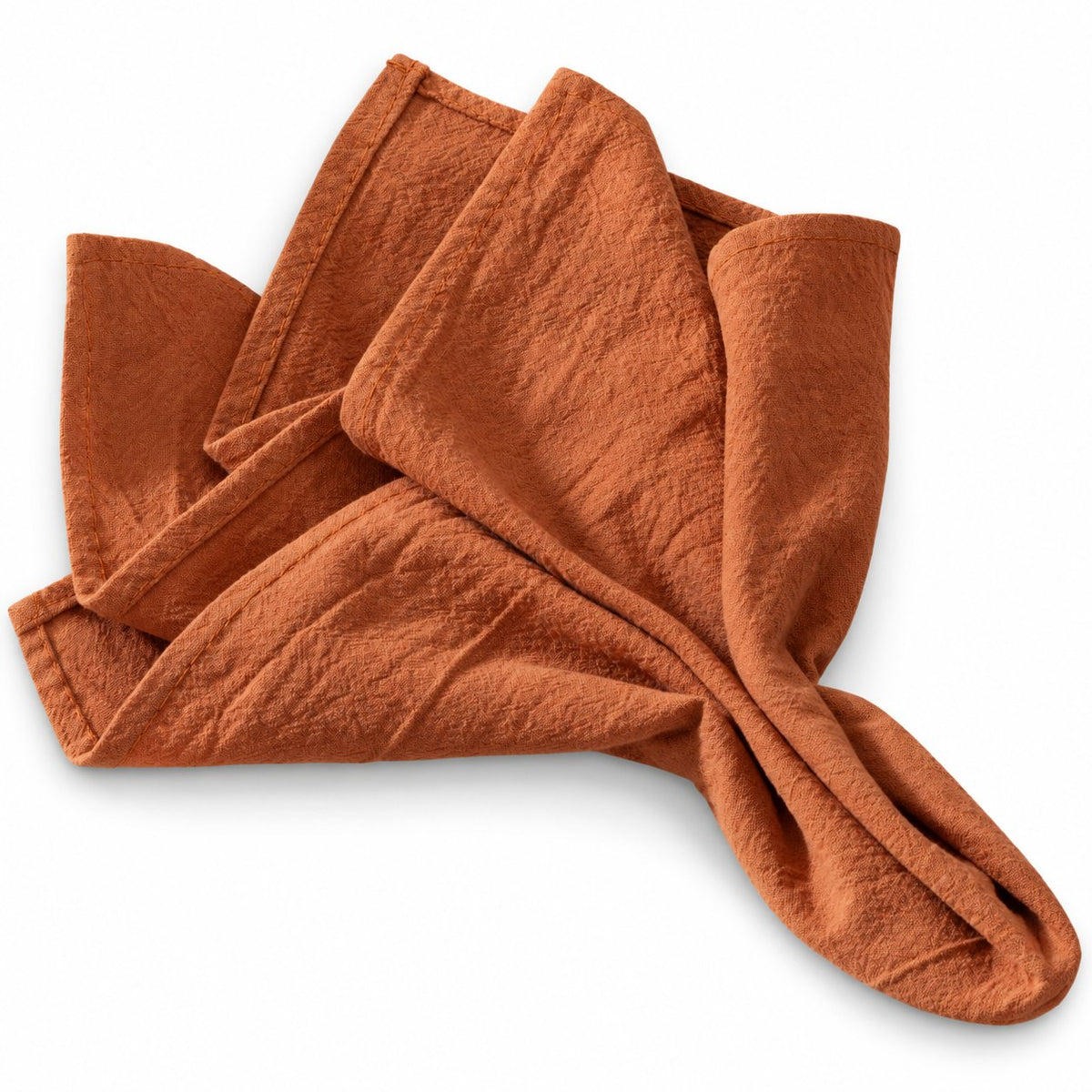 Sailorine rust-colored napkins with a gathered fold and textured surface