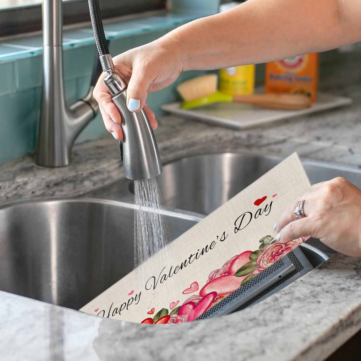 Sailorine heart-and-rose placemat held beneath a running kitchen faucet