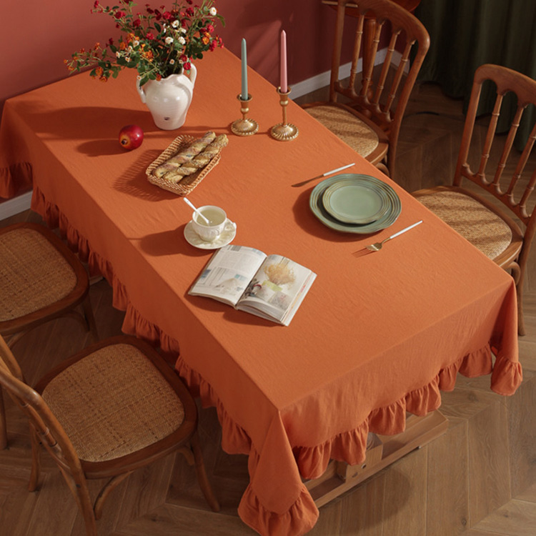Sailorine orange ruffle-edged tablecloth in a dining table setting