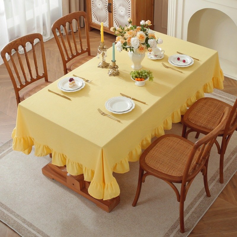 Sailorine yellow ruffle-edged tablecloth on a set dining table