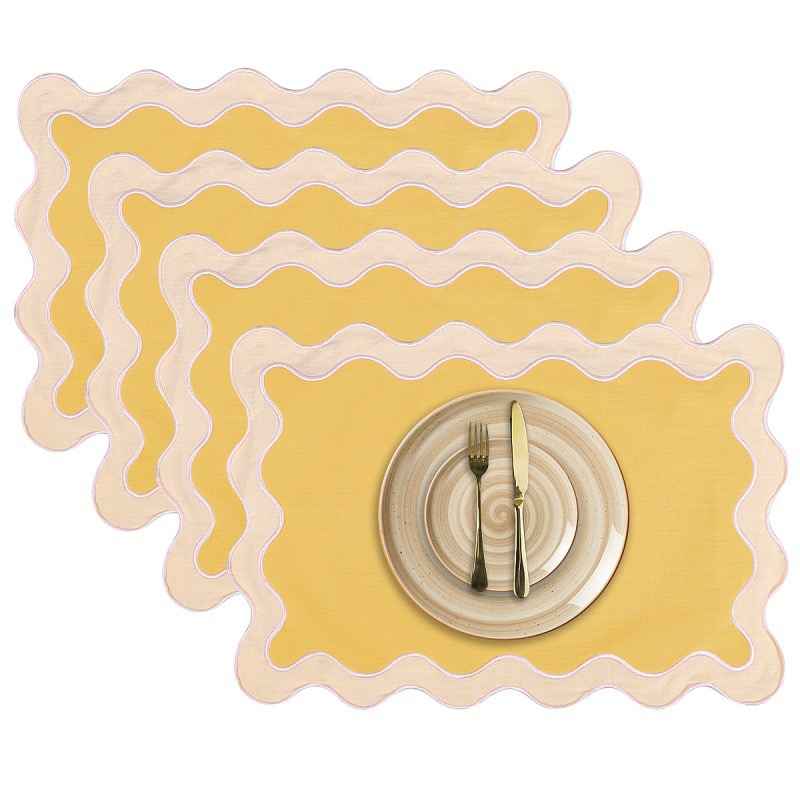 Sailorine yellow scalloped placemats with pale borders shown with a plate