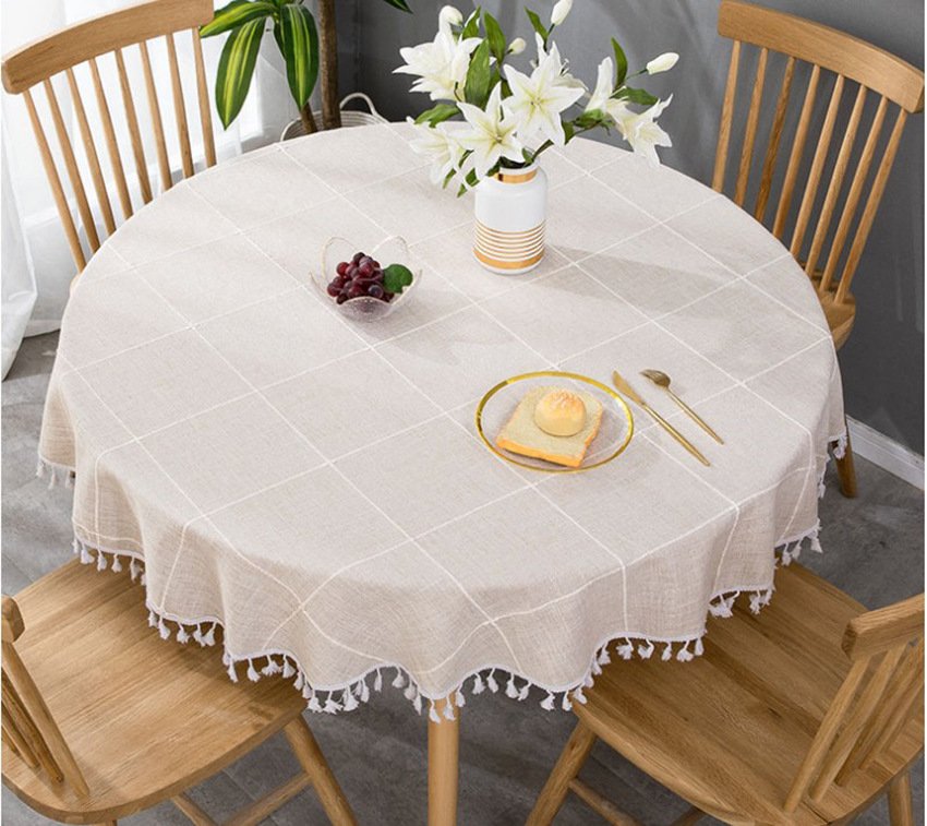Sailorine pale grid-pattern tablecloth beneath a vase on a round dining table