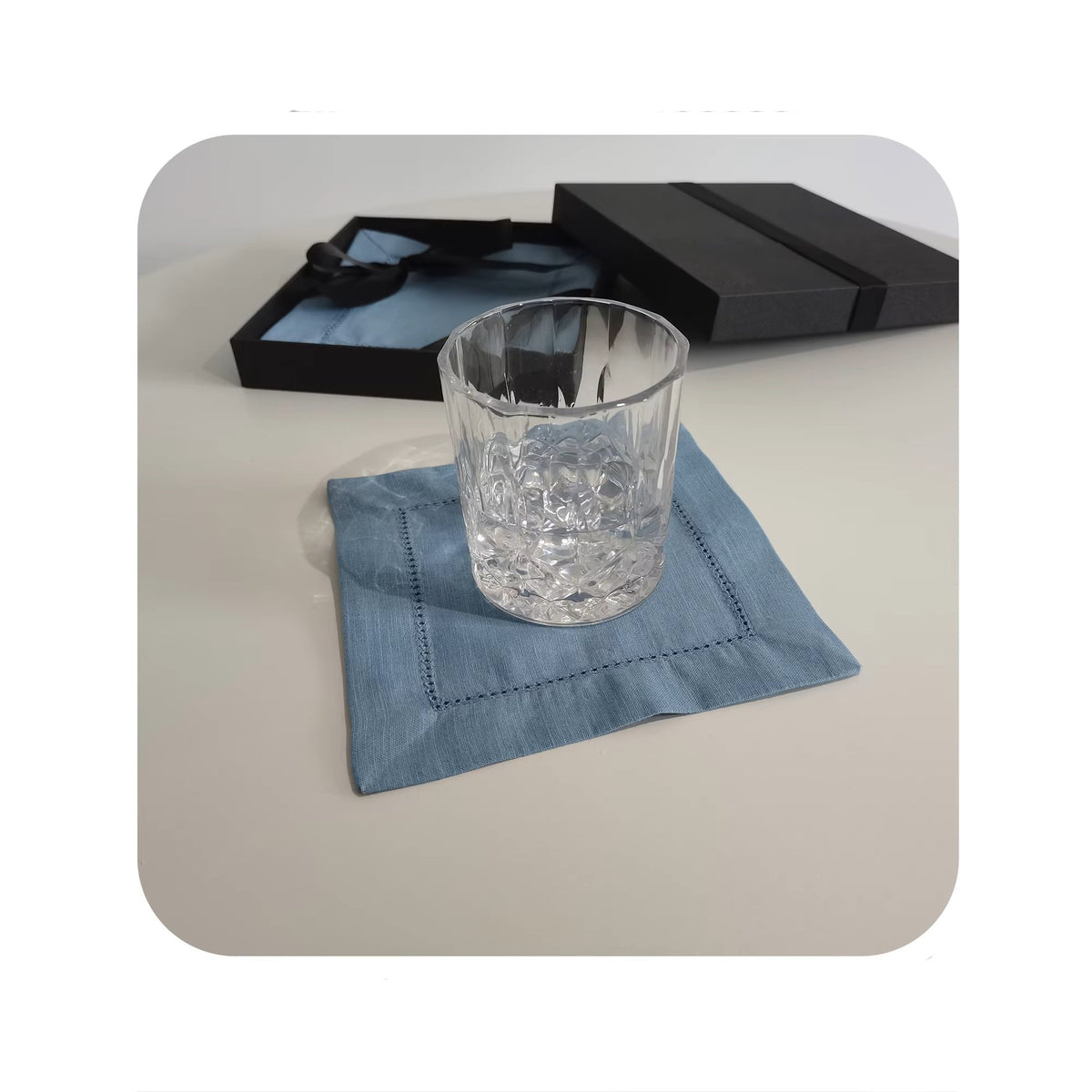 Sailorine blue square napkin beneath a clear drinking glass