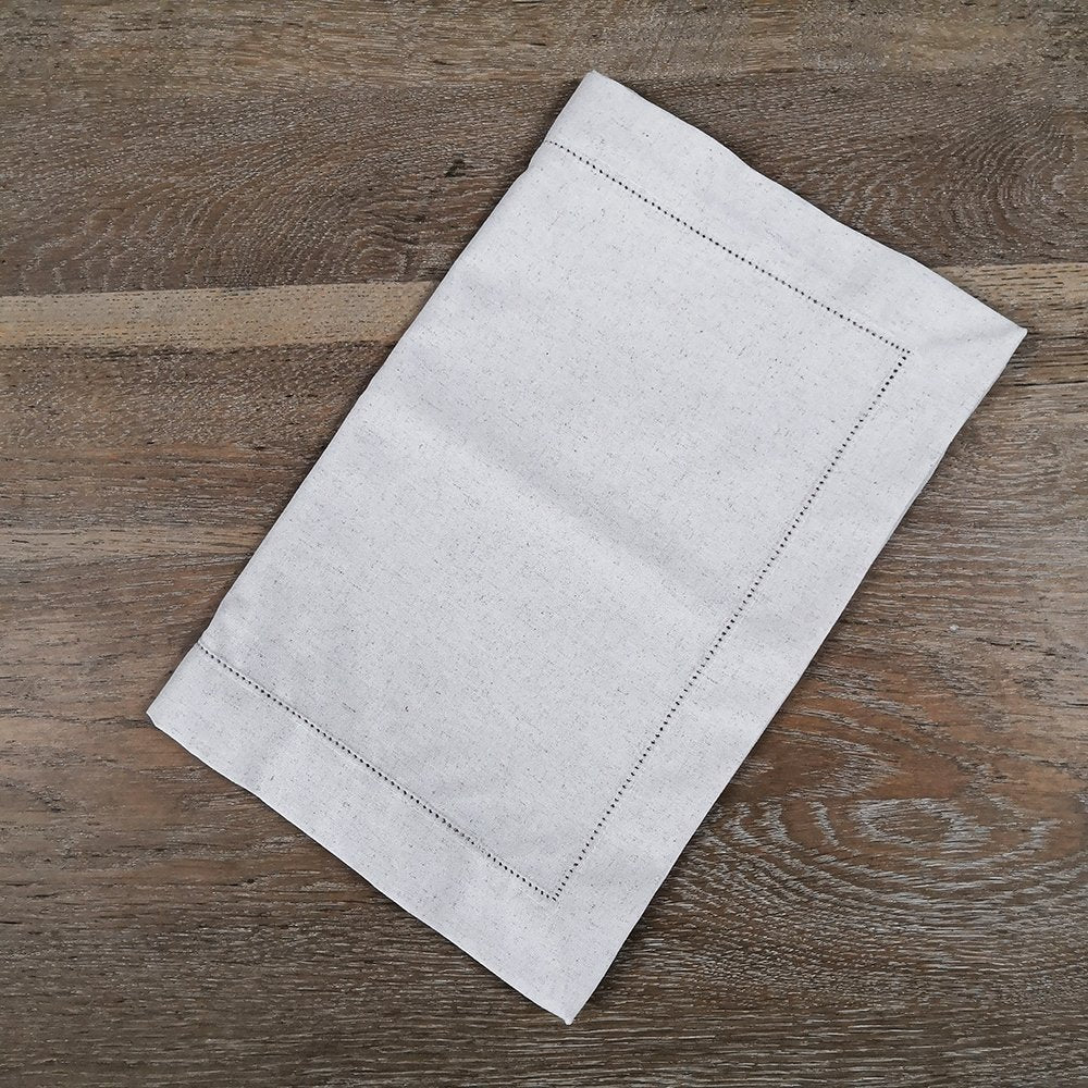 Sailorine folded pale table runner resting on a wooden surface