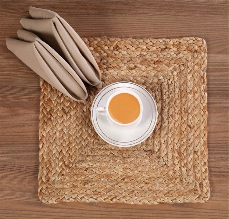 Sailorine brown woven placemat beneath a cup and folded napkin